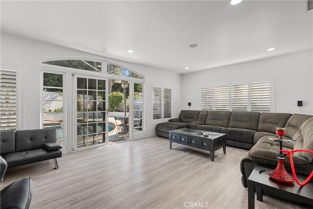 living area with light wood-style flooring, visible vents, and recessed lighting