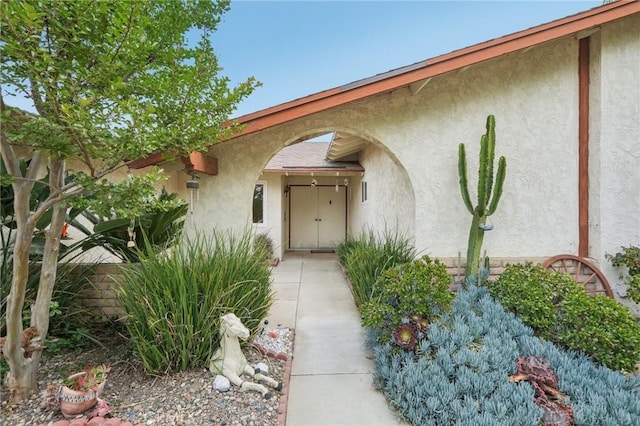 view of exterior entry featuring stucco siding