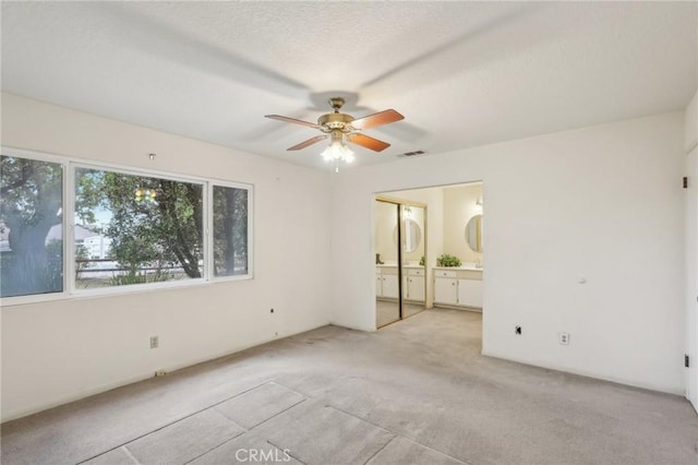 unfurnished bedroom with visible vents, ensuite bathroom, and carpet flooring