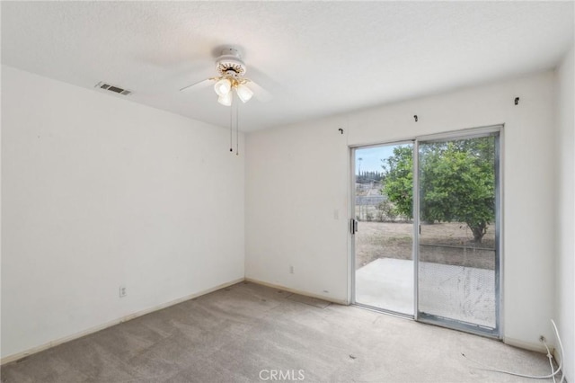 spare room featuring visible vents, ceiling fan, light colored carpet, and baseboards