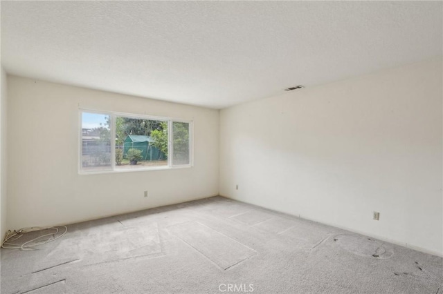 spare room with visible vents and light colored carpet
