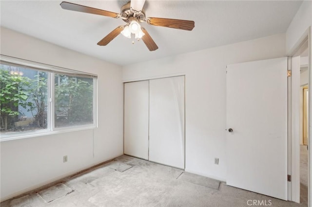 unfurnished bedroom with a closet, ceiling fan, and light colored carpet