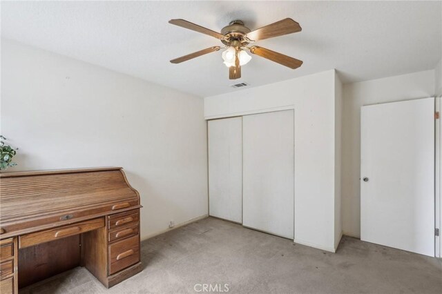 unfurnished bedroom with a closet, visible vents, ceiling fan, and carpet