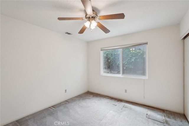 spare room featuring visible vents, light carpet, and ceiling fan