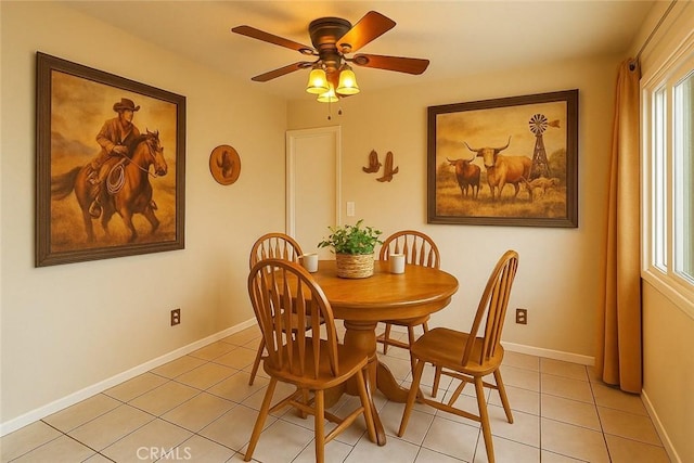 dining area featuring light tile patterned flooring, a ceiling fan, and baseboards
