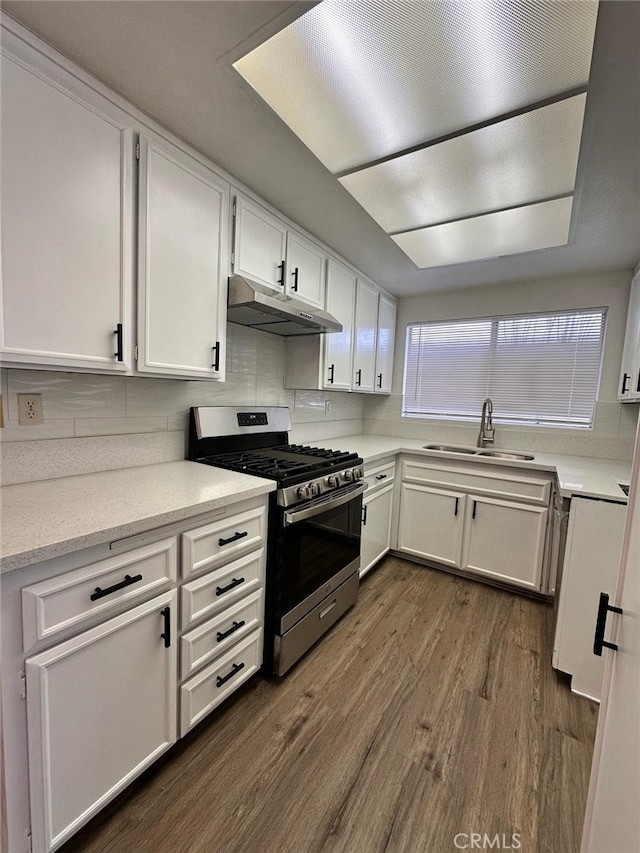 612 S Santa Fe St Unit 4, Hemet, CA 92543 - kitchen featuring dark wood-style floors, white cabinets, under cabinet range hood, stainless steel range with gas stovetop, and a sink
