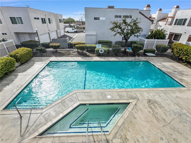 pool featuring a residential view, fence, and a community hot tub