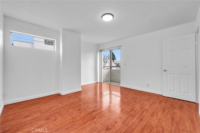 unfurnished room featuring baseboards and light wood-style floors