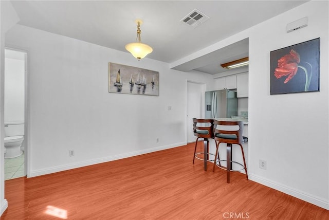 dining room with visible vents, baseboards, and light wood-type flooring