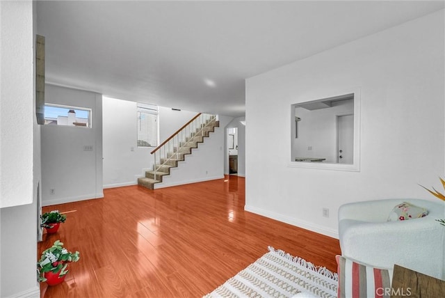 interior space with wood finished floors, baseboards, and stairs