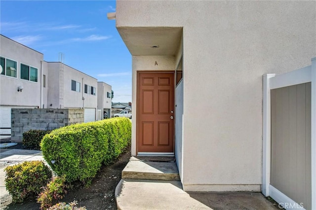 doorway to property featuring stucco siding