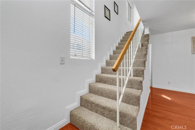 stairs with wood finished floors and baseboards