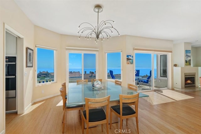 10 Cavalier, Laguna Niguel, CA 92677 - dining area with wood finished floors, a chandelier, and a warm lit fireplace