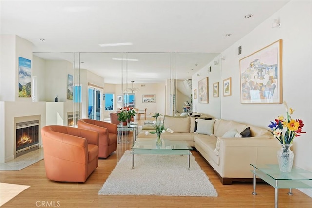 living area with a glass covered fireplace and light wood-style floors