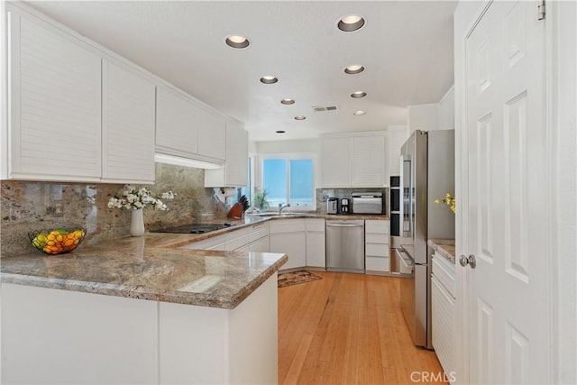 10 Cavalier, Laguna Niguel, CA 92677 - kitchen featuring stainless steel appliances, a peninsula, tasteful backsplash, white cabinetry, and recessed lighting