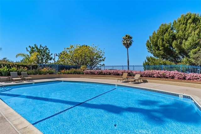 pool with a patio and fence