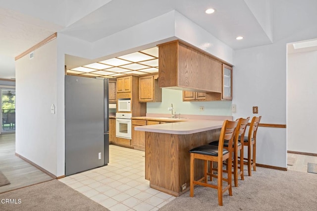 342 Colgate St, Santa Paula, CA 93060 - kitchen with a sink, light countertops, a kitchen breakfast bar, white appliances, and a peninsula