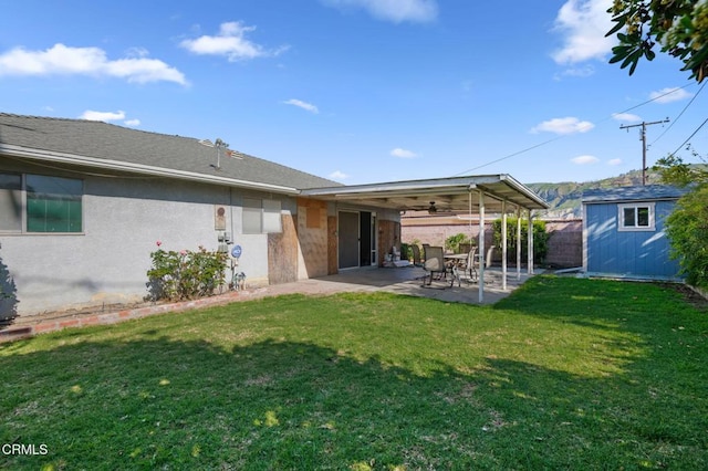 342 Colgate St, Santa Paula, CA 93060 - rear view of house featuring a patio, stucco siding, an outbuilding, a lawn, and a storage unit