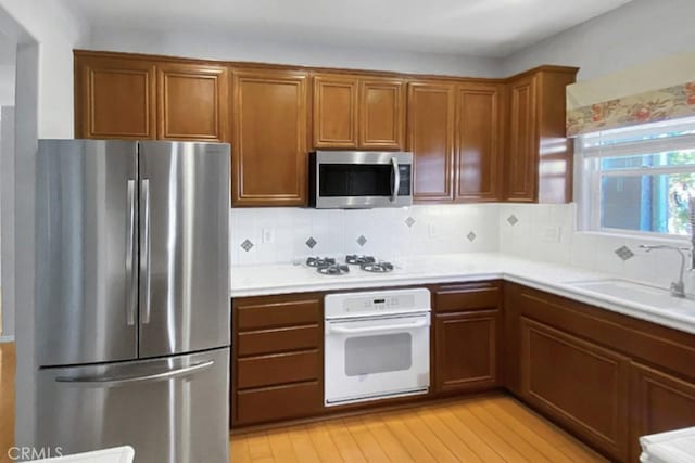 1961 Devaul Ranch Dr, San Luis Obispo, CA 93405 - kitchen featuring a sink, brown cabinets, backsplash, light countertops, and appliances with stainless steel finishes