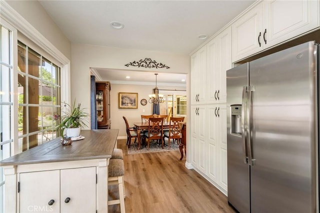 17851 Nearbank Dr, Rowland Heights, CA 91748 - kitchen featuring stainless steel countertops, white cabinets, light wood-style flooring, crown molding, and stainless steel fridge with ice dispenser