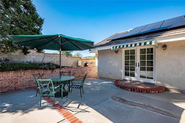 view of patio / terrace featuring outdoor dining area, french doors, and fence