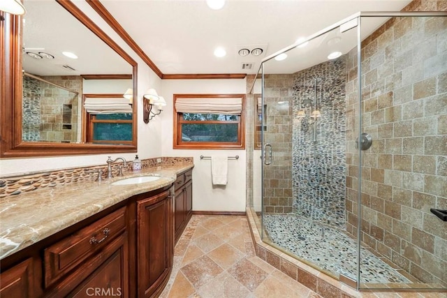 bathroom featuring vanity, baseboards, crown molding, and a stall shower