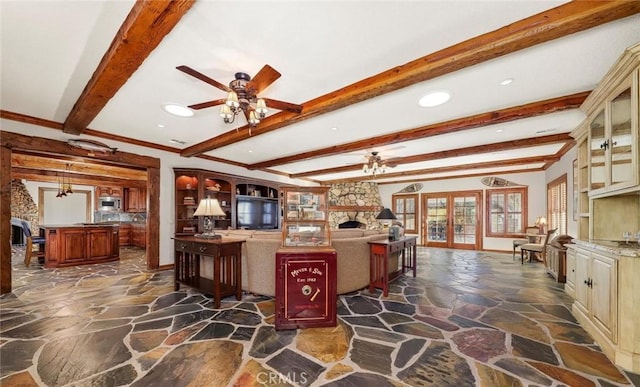 kitchen with ceiling fan, beam ceiling, stone floors, recessed lighting, and cream cabinets
