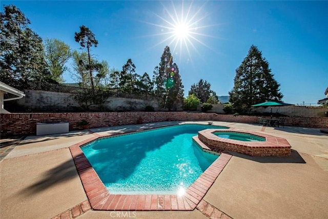view of swimming pool with a fenced backyard, a pool with connected hot tub, a patio, and a diving board