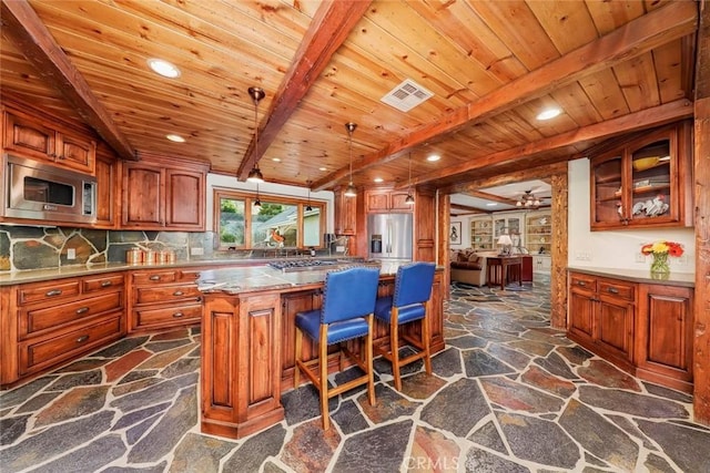 kitchen featuring visible vents, wood ceiling, stone floors, and stainless steel appliances