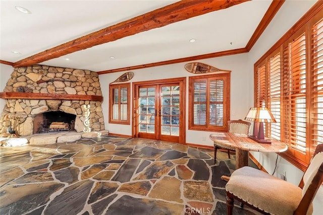 living area with crown molding, stone floors, and plenty of natural light