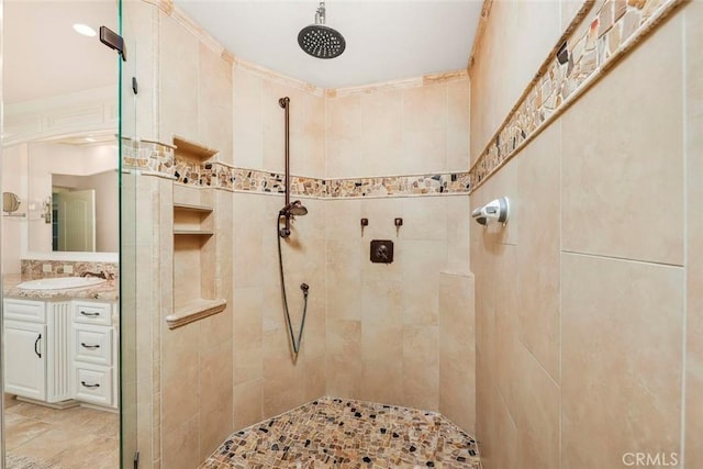 full bath with tiled shower and vanity