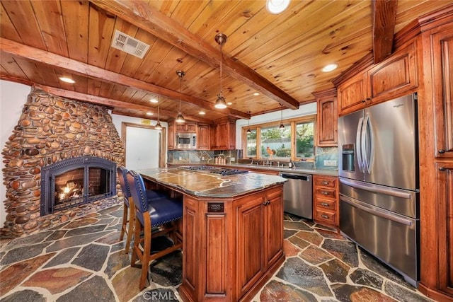 kitchen with stone floors, brown cabinets, appliances with stainless steel finishes, and visible vents