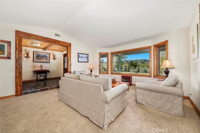 carpeted living area featuring visible vents, baseboards, and lofted ceiling