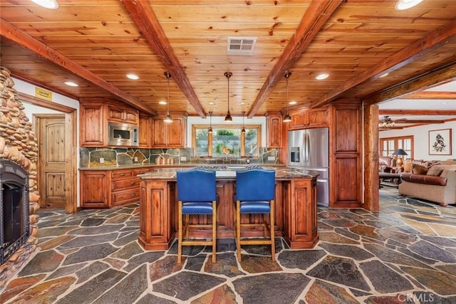 kitchen with stone floors, appliances with stainless steel finishes, visible vents, and wooden ceiling
