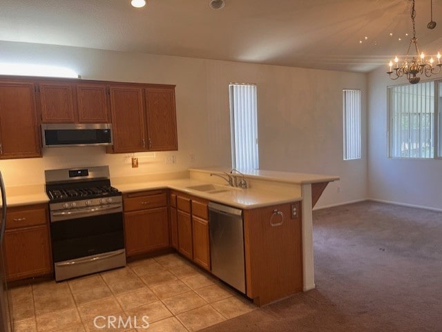 11950 Reichling Ln, Whittier, CA 90606 - kitchen featuring a notable chandelier, a sink, light countertops, a peninsula, and stainless steel appliances