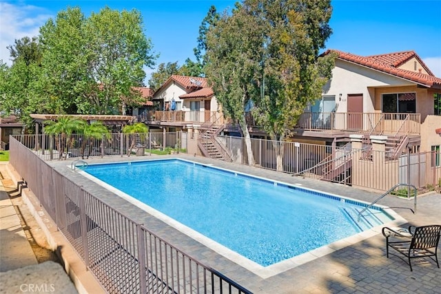 778 La Tierra St Unit H102, Corona, CA 92879 - community pool featuring stairs, a residential view, and a patio