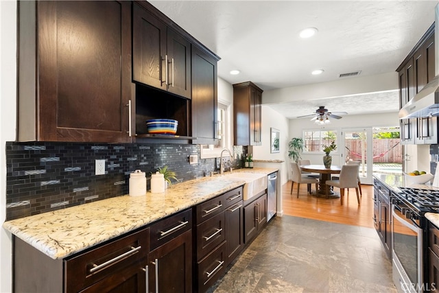 kitchen with appliances with stainless steel finishes, a sink, a ceiling fan, decorative backsplash, and visible vents