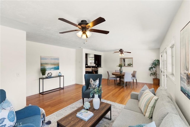 living room with a ceiling fan and wood finished floors