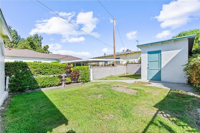 view of yard featuring an outdoor structure, a storage unit, and fence