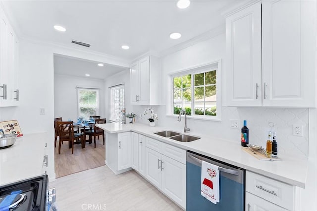 kitchen with a wealth of natural light, appliances with stainless steel finishes, ornamental molding, and a sink