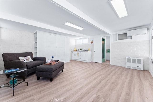 living room with light wood finished floors, heating unit, and a wall mounted AC