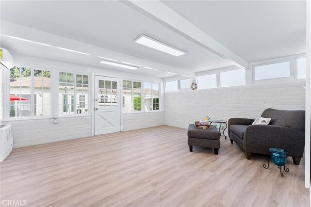 sunroom / solarium featuring beamed ceiling