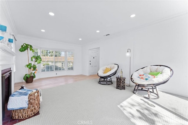 living area with baseboards, visible vents, recessed lighting, crown molding, and a fireplace