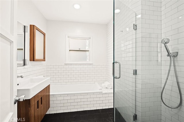 full bathroom featuring vanity, tile patterned flooring, a shower stall, tile walls, and a garden tub