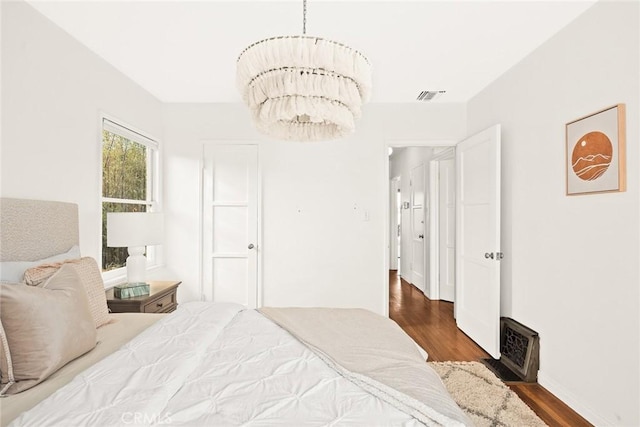 bedroom featuring wood finished floors and visible vents