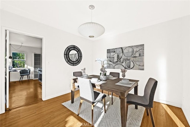 dining space featuring baseboards and wood finished floors