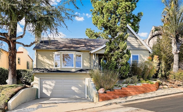 view of front of property featuring an attached garage, driveway, and stucco siding