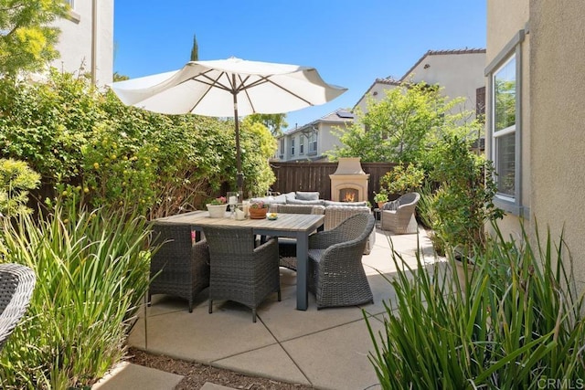 3477 Filoli Cir, Carlsbad, CA 92009 - view of patio / terrace with a warm lit fireplace and outdoor dining area