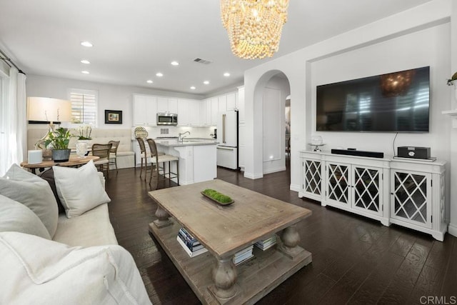 3477 Filoli Cir, Carlsbad, CA 92009 - living area featuring arched walkways, a chandelier, recessed lighting, dark wood-type flooring, and baseboards