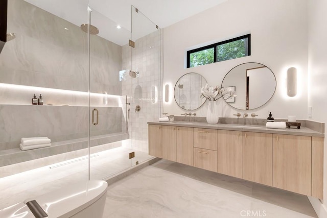 full bath with a sink, toilet, double vanity, and a stall shower